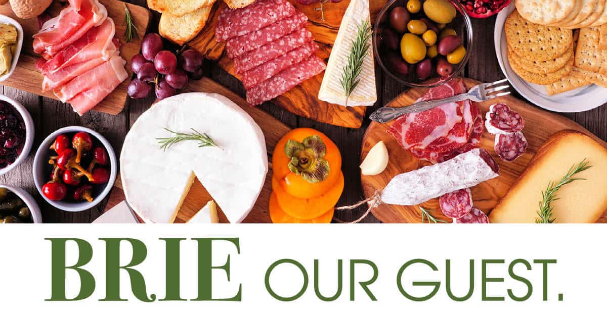 Brie Our Guest event image with large variety of charcuterie spreads above.