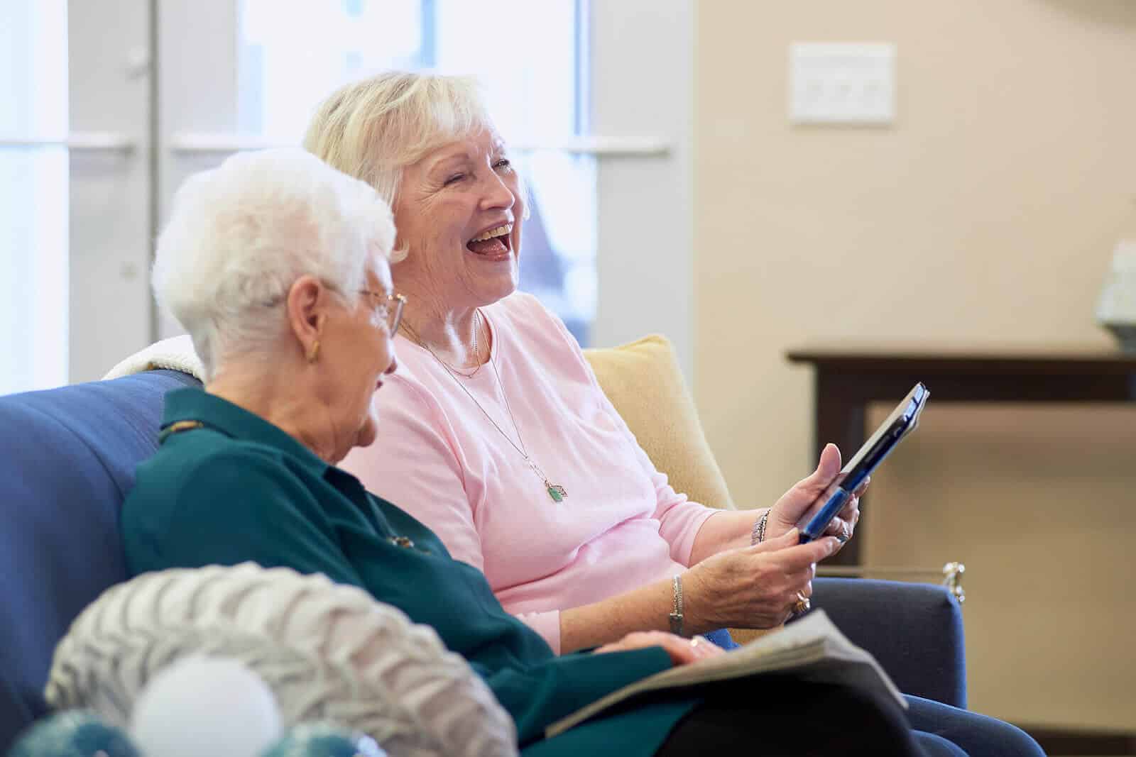 residents looking at a tablet and laughing