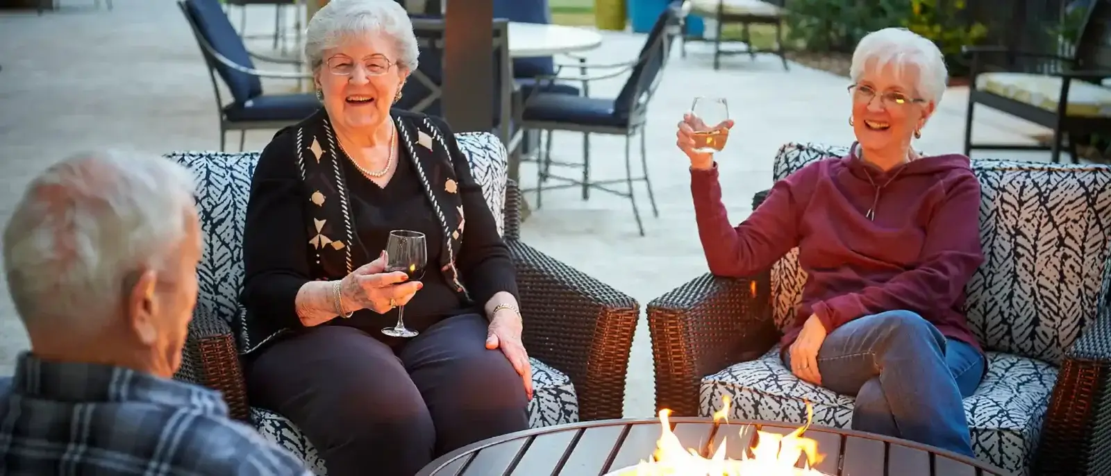 friends enjoying a drink around the fire at park creek